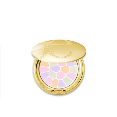 Compact powder with colorful shades and gold casing on a white background