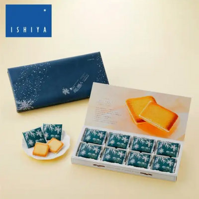 A box of Ishiya Shiroi Koibito Langue de chat Cookies, with 24 pieces. The packaging is predominantly blue with images of the white chocolate cookies and orange citrus peels used in the recipe.