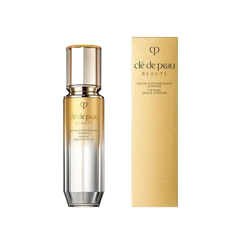 Shiseido Clé de Peau Beáuté Firming Serum Supreme packaging and bottle, with the product box being primarily beige and the bottle being transparent with a gold cap.