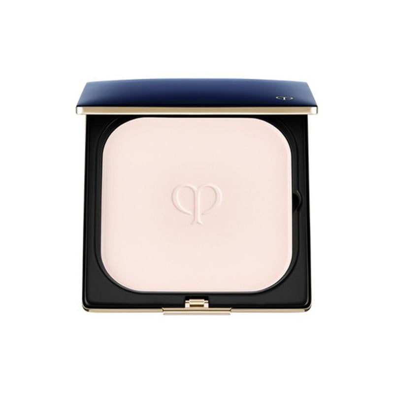 A compact case of Clé de Peau Beäuté Refining Pressed Powder with a pink-toned powder visible through the transparent lid, featuring a gold-tone floral logo on the front.