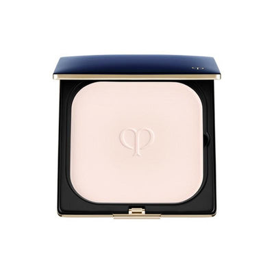 A compact case of Clé de Peau Beäuté Refining Pressed Powder with a pink-toned powder visible through the transparent lid, featuring a gold-tone floral logo on the front.
